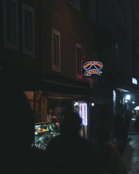 people at night looking at an old fashion shop in the town