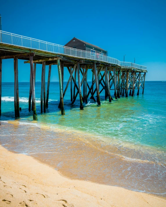 a long wooden pier with clear blue skies in the background