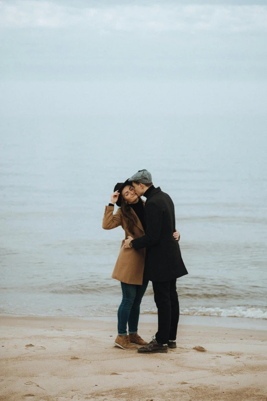 a man and woman sharing a kiss while they are on the beach