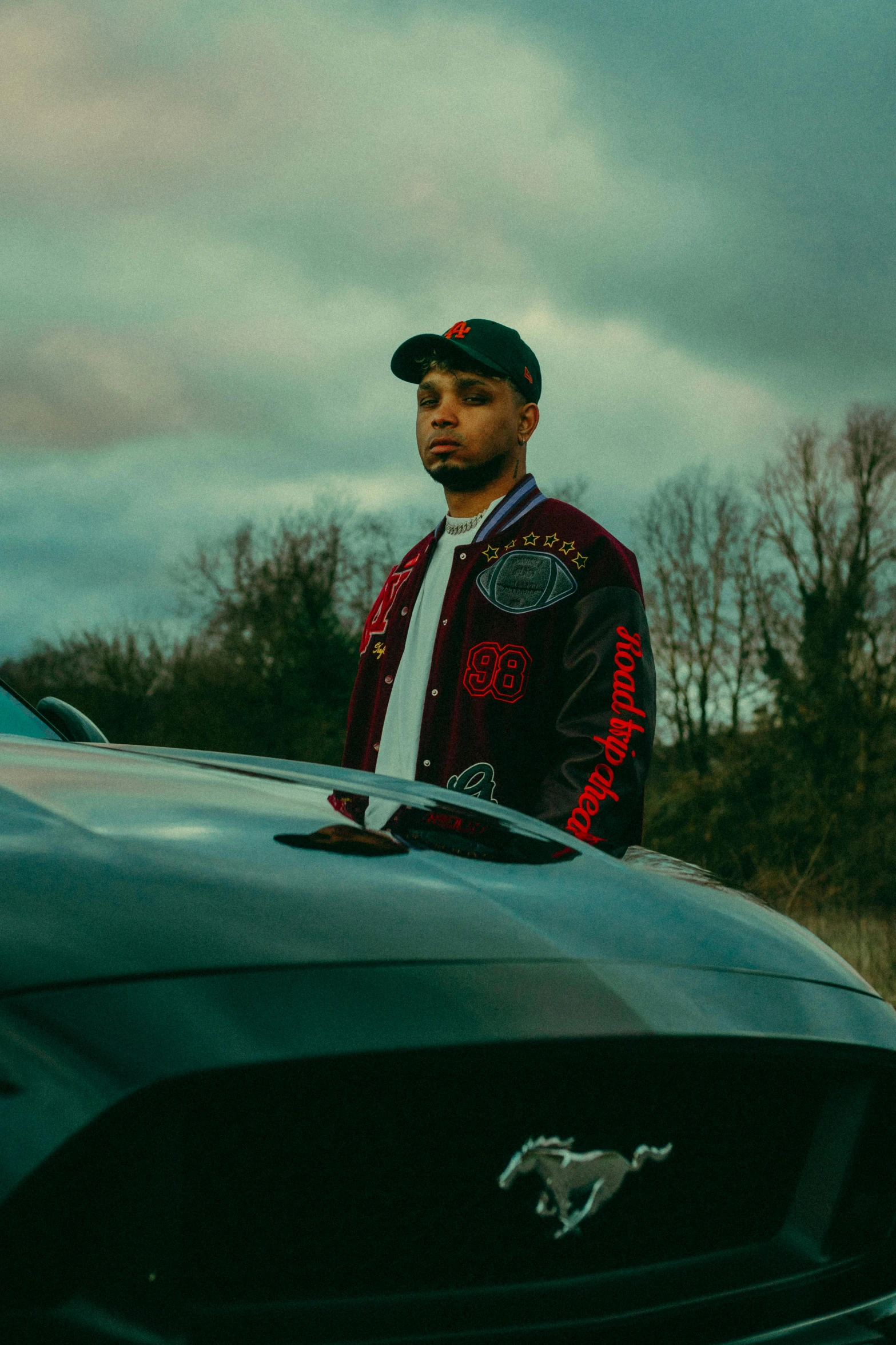 a man standing on top of a sports car