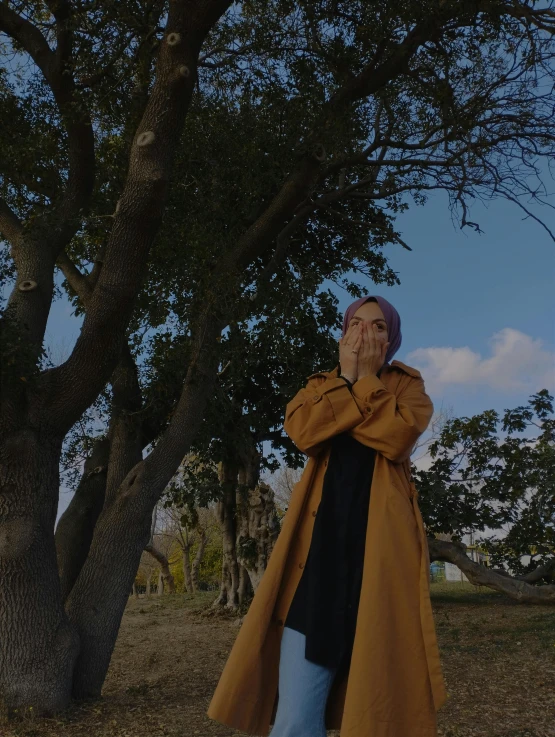 a man leaning on a tree while looking at the sky