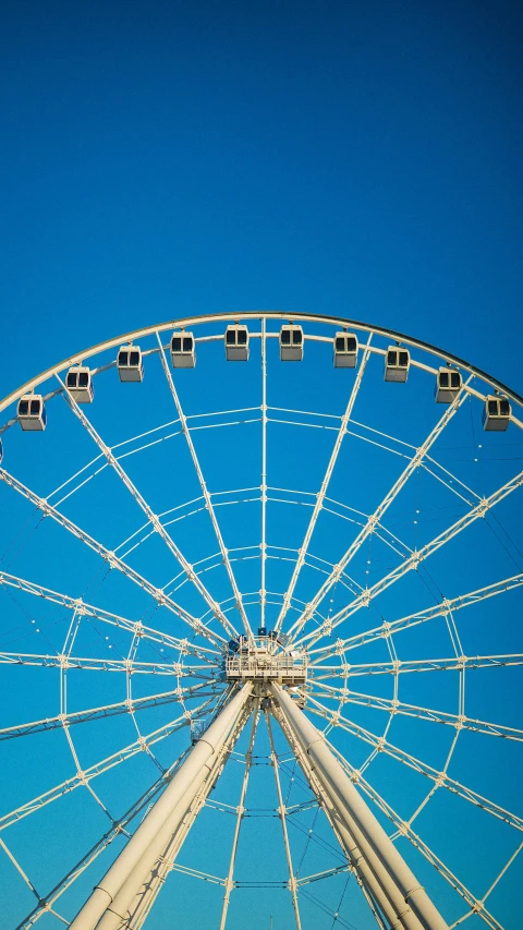 a large ferris wheel at a carnival rides on a clear day