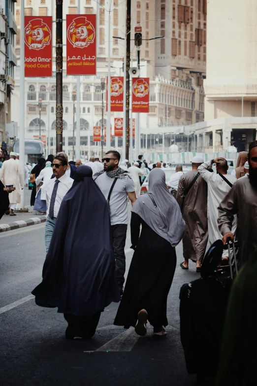 many people walk down the street as others carry luggage