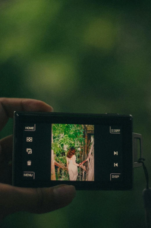 a person holding a camera in their hand taking a picture of a woman on the camera