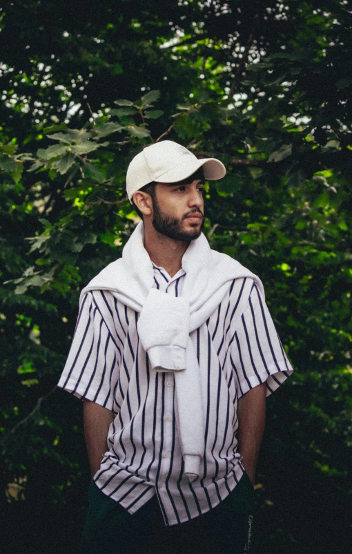 a bearded man wearing a baseball cap and scarf