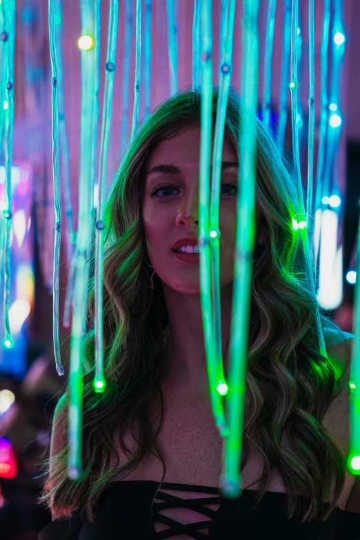 a woman looking in the mirror with lights hanging from her face