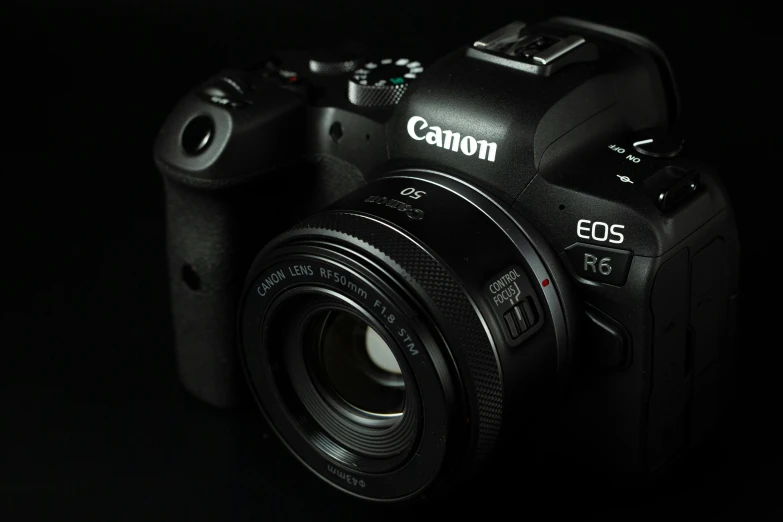 a canon camera sitting against a dark backdrop