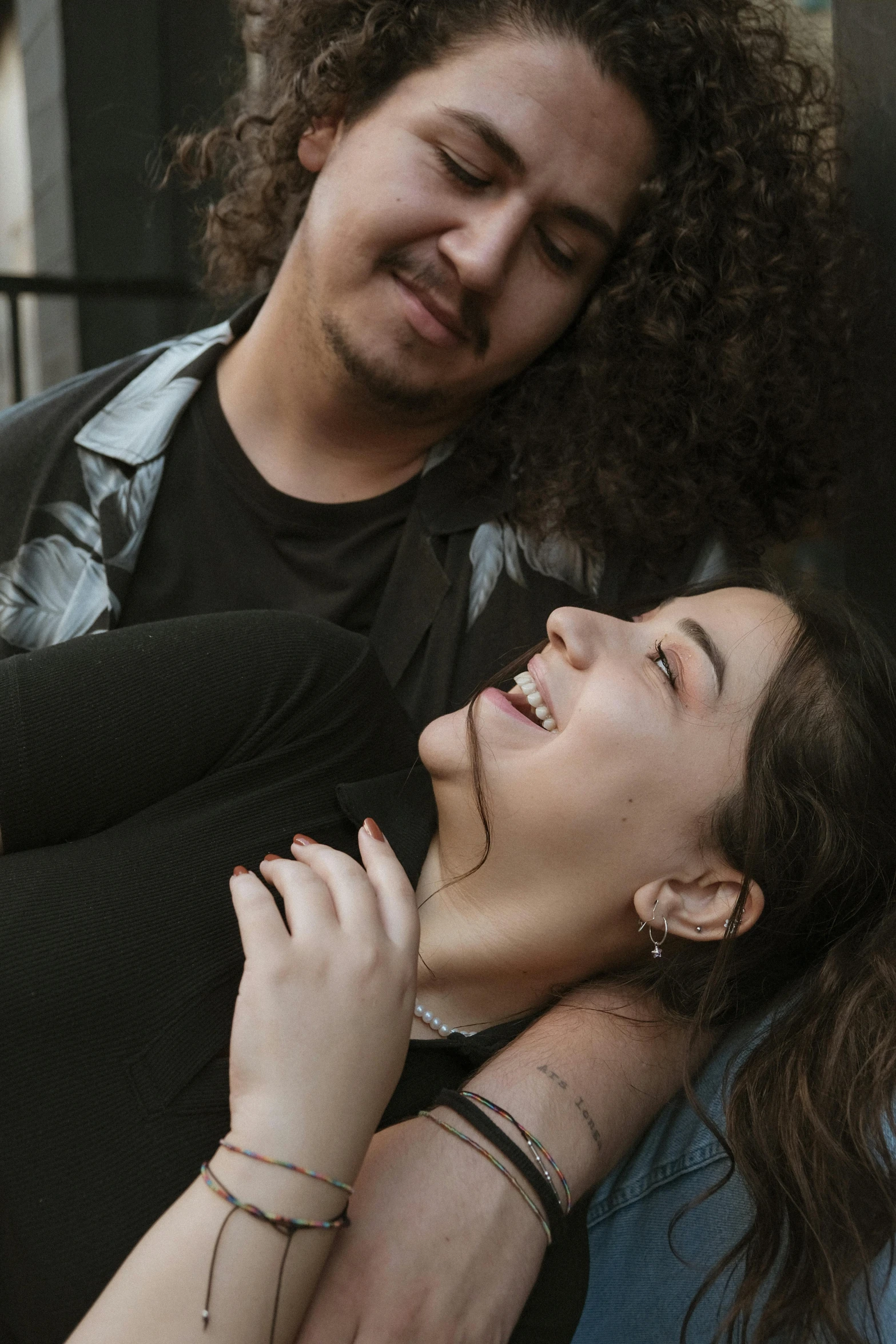 a man hugging a woman while smiling and laughing