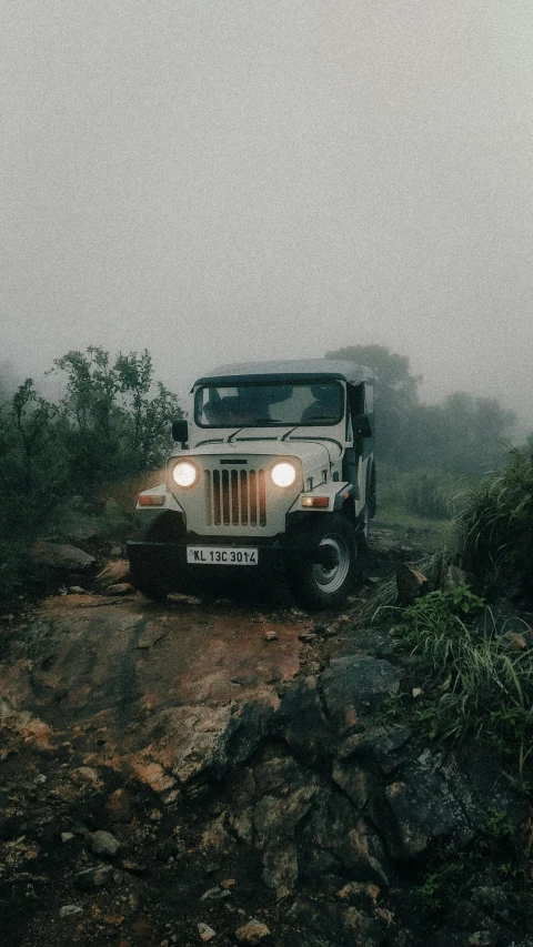 a jeep driving in the mud during a cloudy day