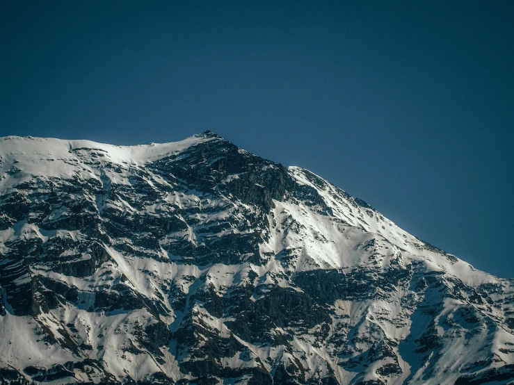 a large snowy mountain with no cloud in the sky