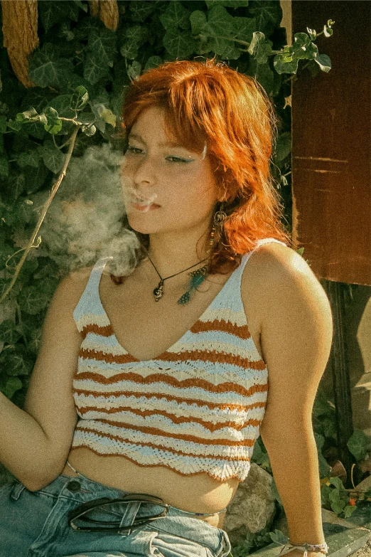 an orange haired girl smokes a cigarette in her tank top