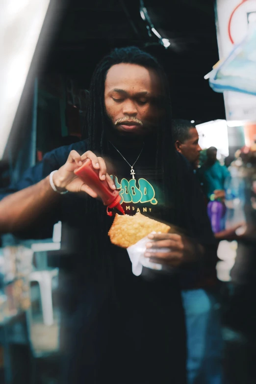 man with dreadlocks eating out of a container