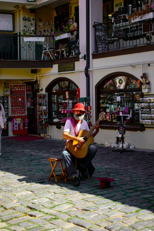 a man sitting on a chair while holding a guitar