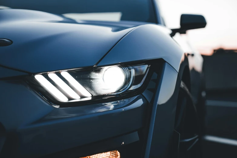 the headlights of a black sports car with its headlights on