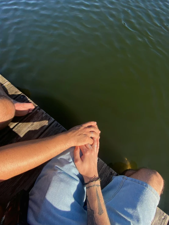 there are two people that are sitting on a dock