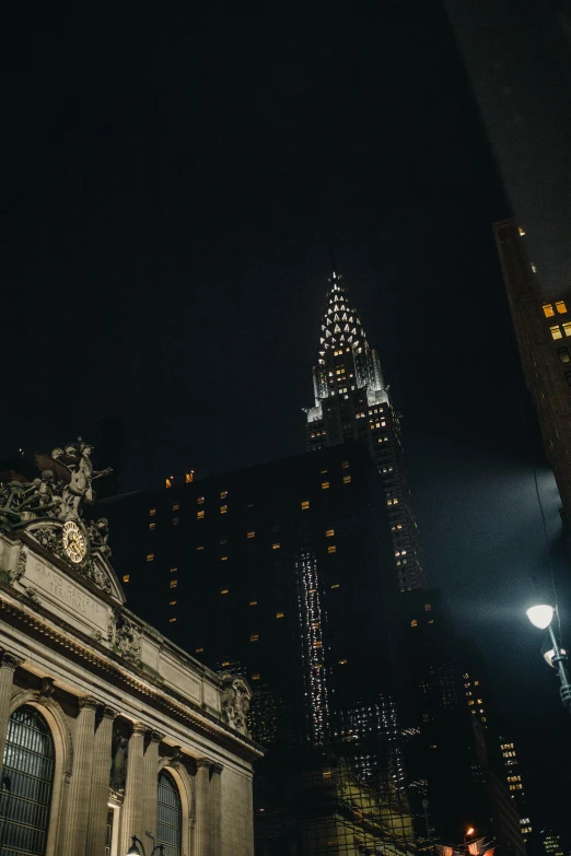 a very tall building near another tall building at night