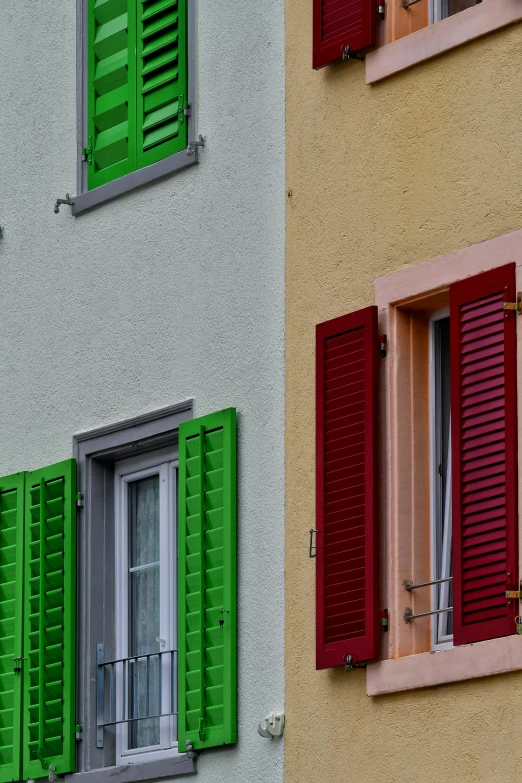 two colorful buildings with red and green shutters on them