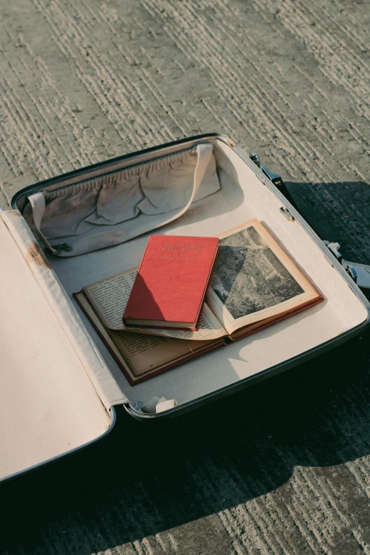 a suitcase filled with papers and folders sits on the ground