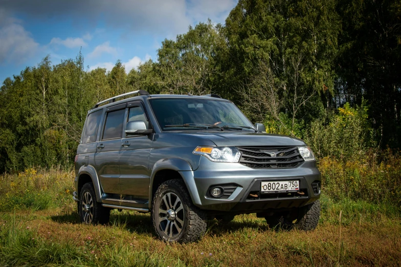 a silver suv that is parked in the grass