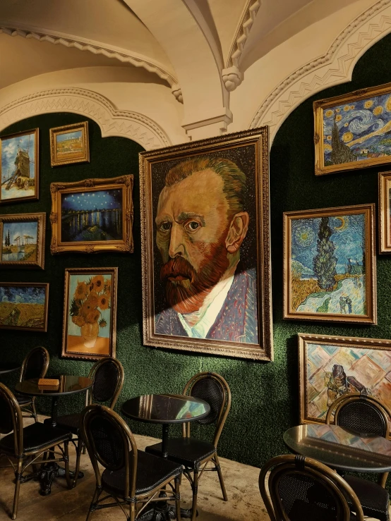 many paintings on the walls and chairs against a wall