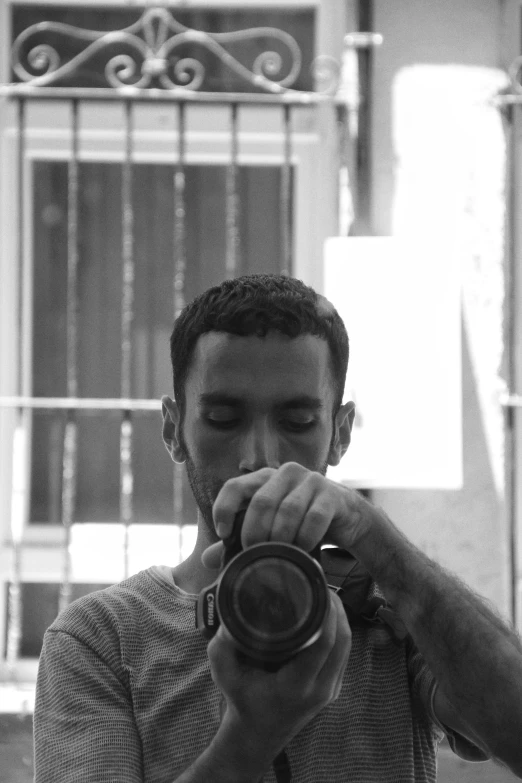 a man with glasses holding a camera near his face