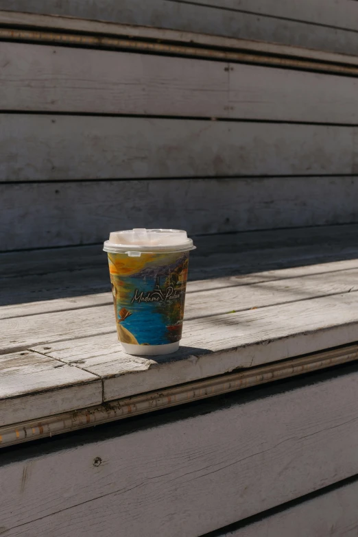 a cup is sitting on top of a bench