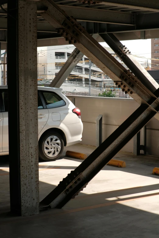 there is a white car parked next to a bridge