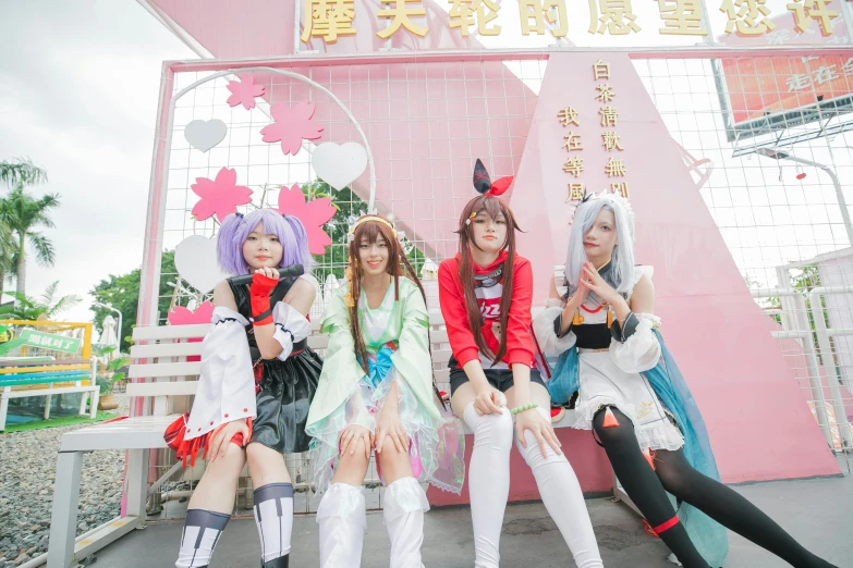 three women dressed in costumes sitting on a bench