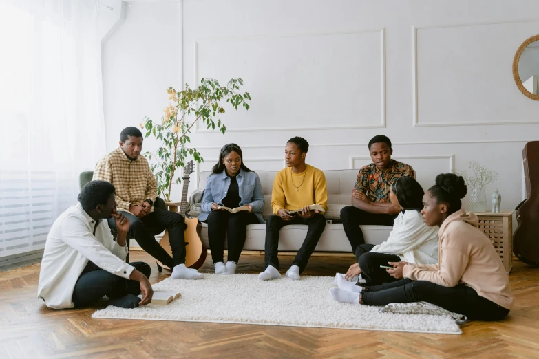 group of adults sitting on bench in living room on rug with wood floor