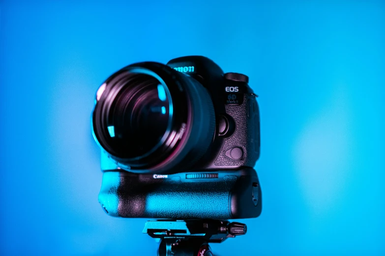 a blue lit background with a camera sitting on top of it