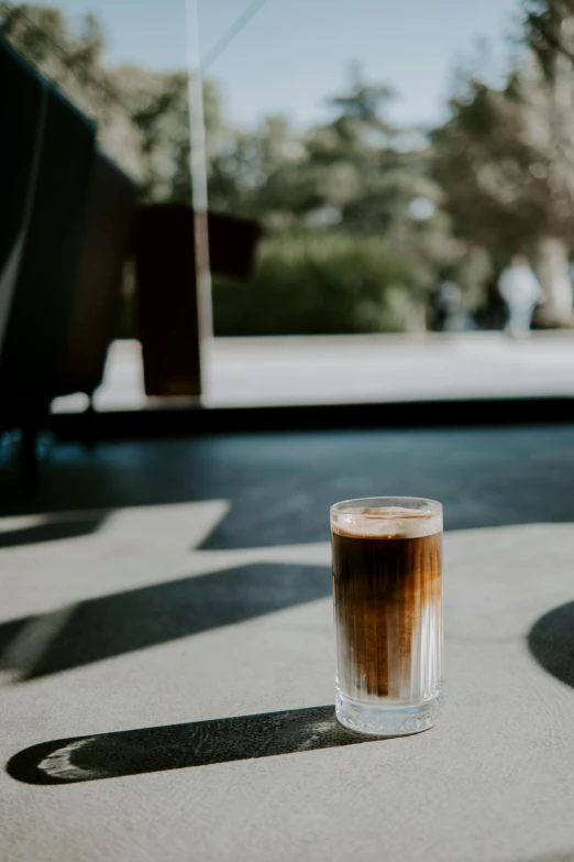 a cup of coffee sits alone on the ground