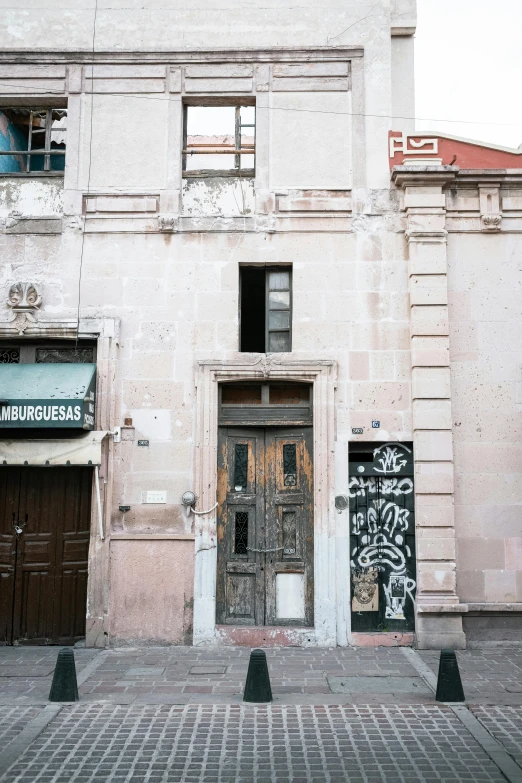 an old building with a door and graffiti on it