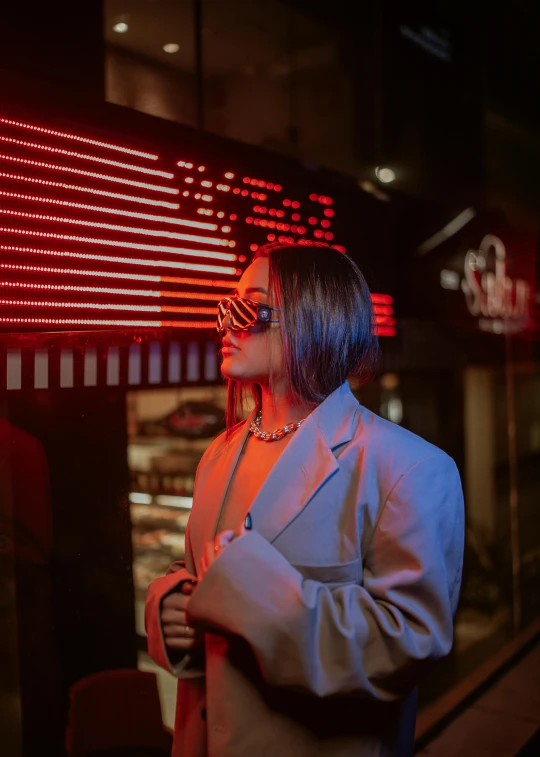 a woman with glasses is standing in front of a store window