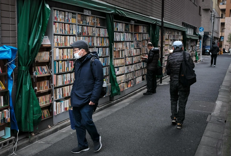 a man walks down the street while wearing a mask