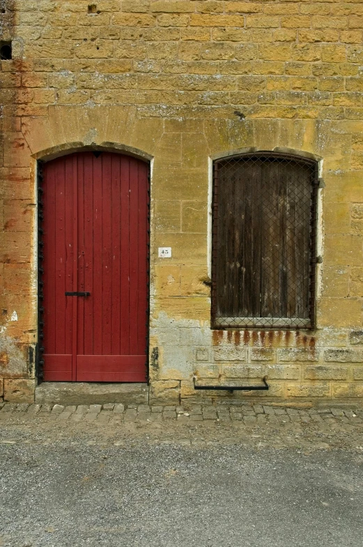 two windows with a wooden door at an old building