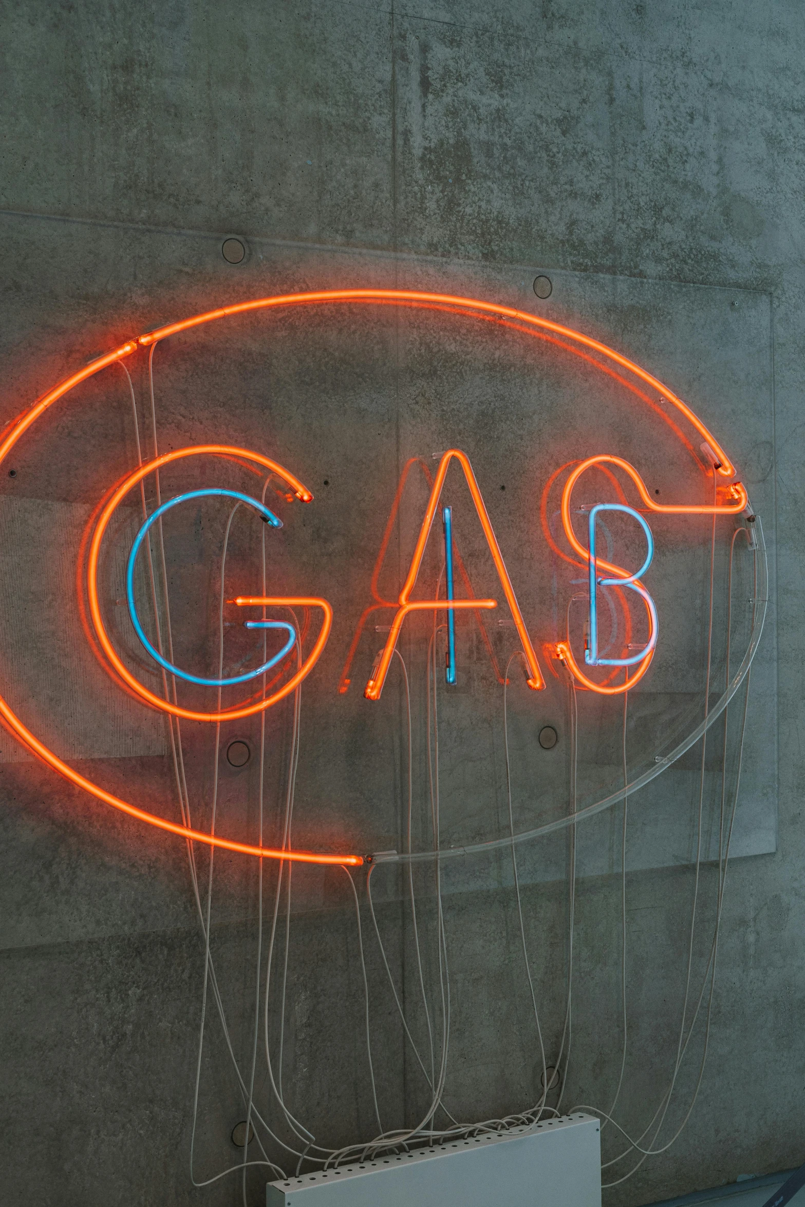 a sign on a building that reads gas and has neon writing underneath it