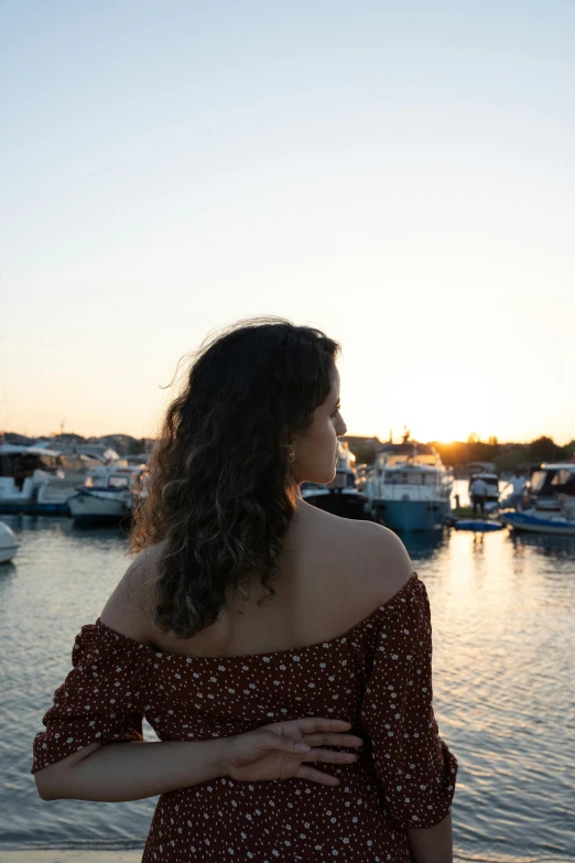 a woman in a polka dot top standing by the water