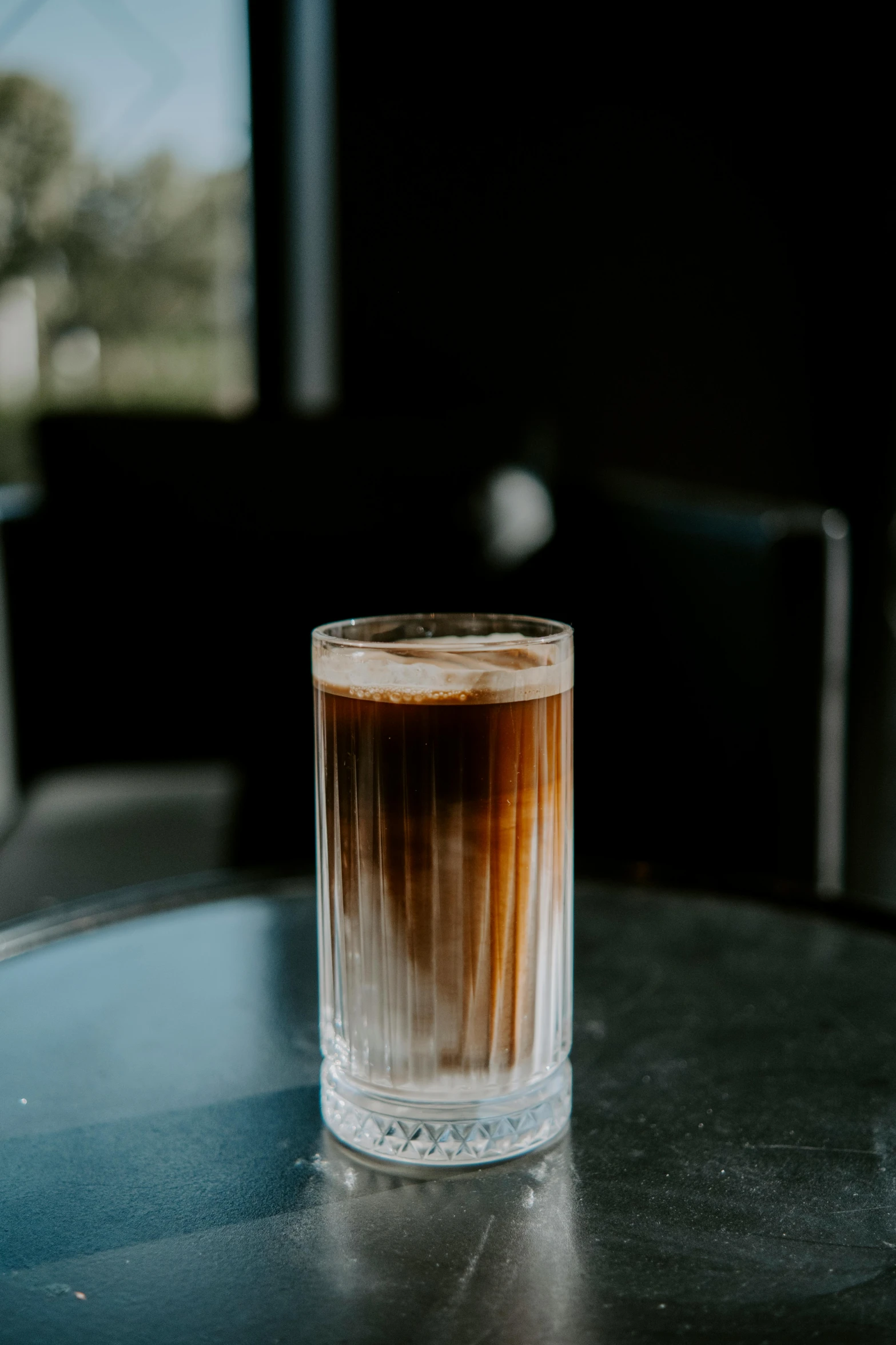 a glass with liquid sitting on top of a table