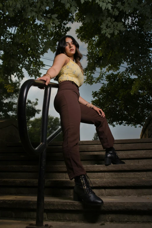 a woman is sitting on some stairs posing for the camera