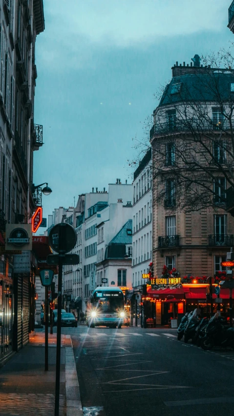 a city street with many vehicles driving in the dark