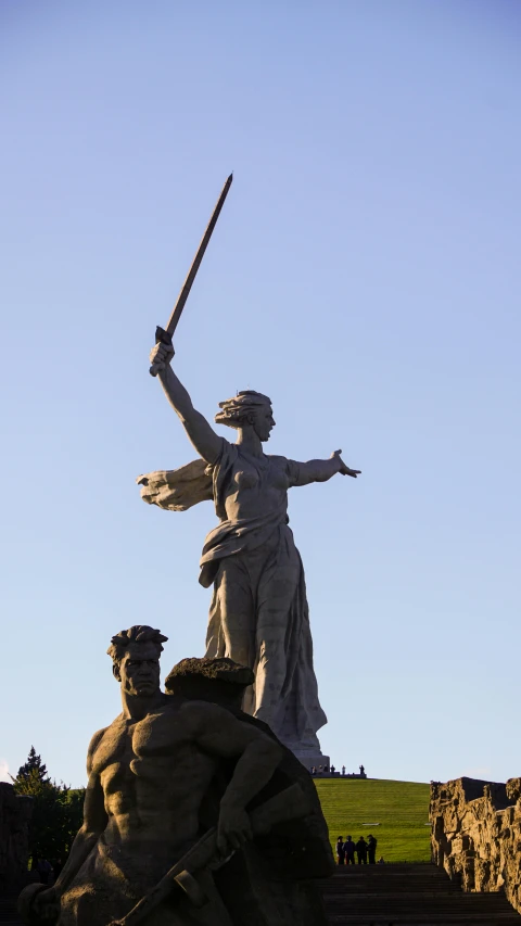 a statue is sitting on some rocks