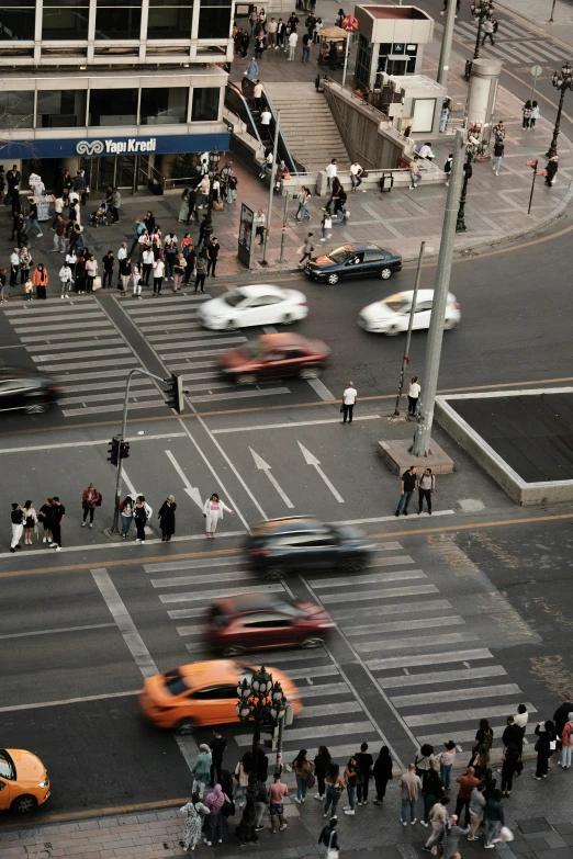 many cars are on the road as people stand on the side walk