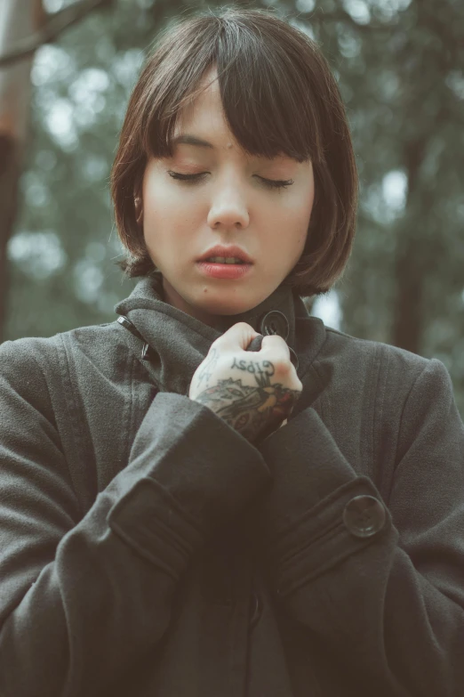 the woman is wearing a hoodie in the woods