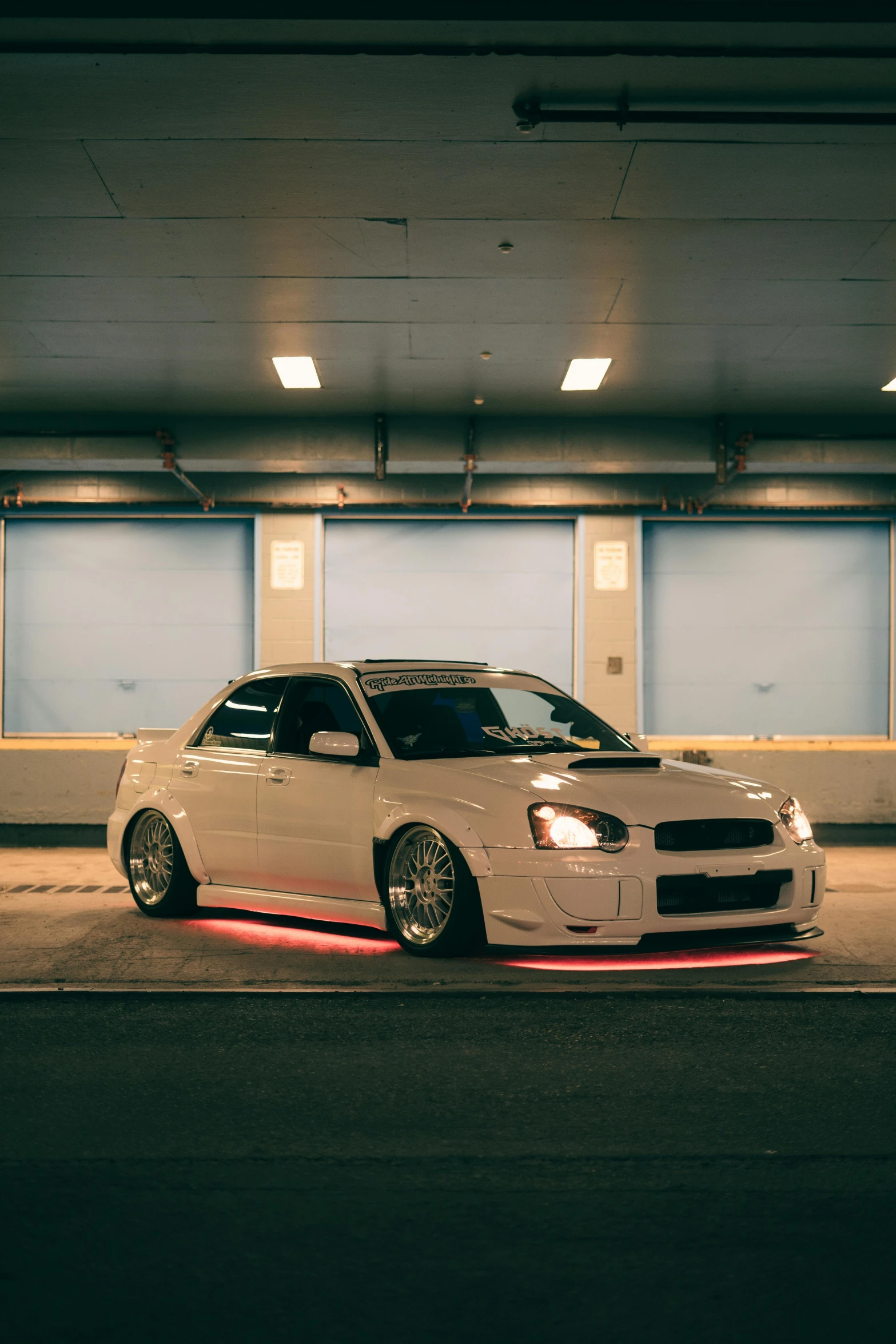 a car parked in a parking garage with the door open