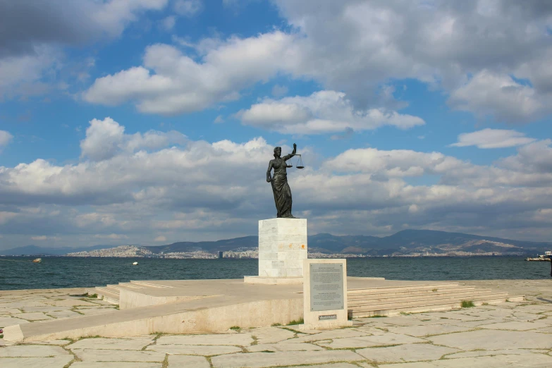 statue of an individual on a ledge near the water