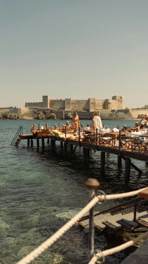 some people are eating at a table near the water