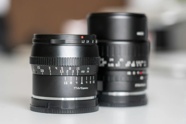 three black camera lenses sitting on top of a table