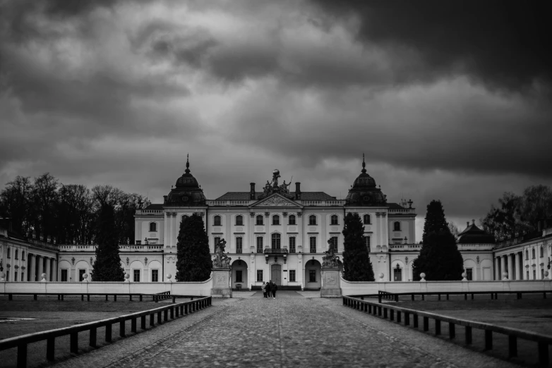 a white building with black and white clouds above