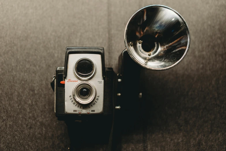 a brown and black camera some metal items and a lamp