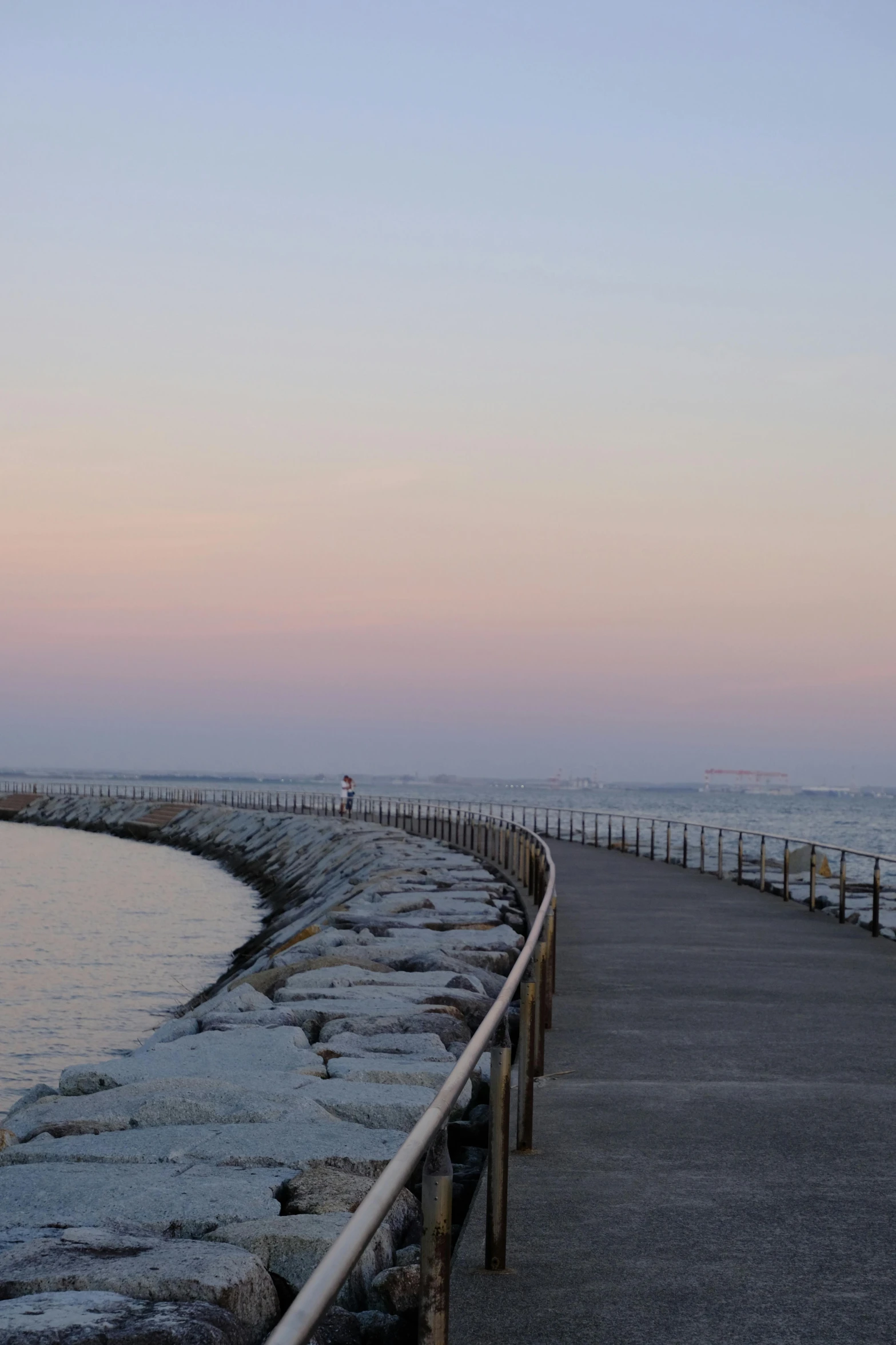 a bench sits near the water at dusk